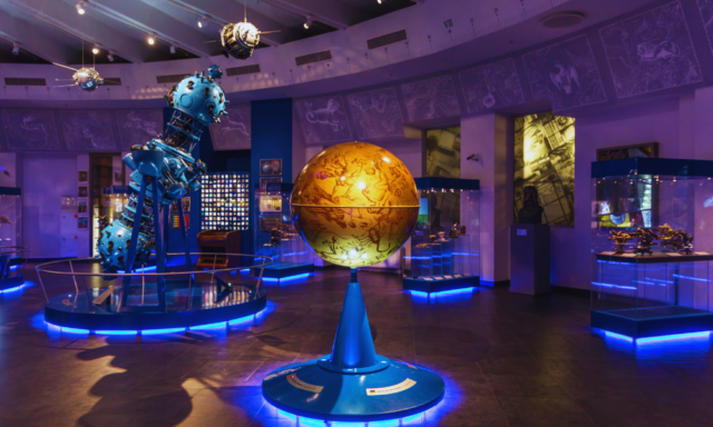 View of a science museum exhibition featuring a globe, and space-related displays.