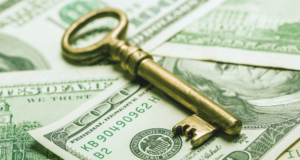 Money Talks: Income Generation for Museums A golden key on top of a pile of American $100 bills.