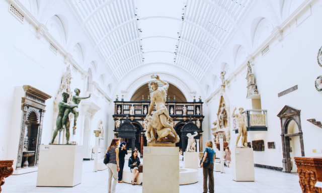 Museum visitors looking at an ancient marble sculpture.