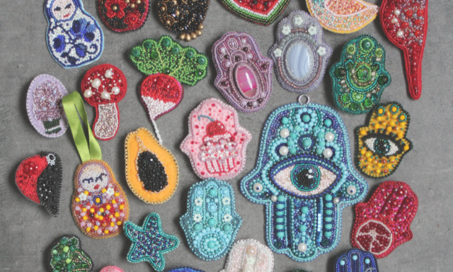 A collection of handmade beaded brooches on a table.