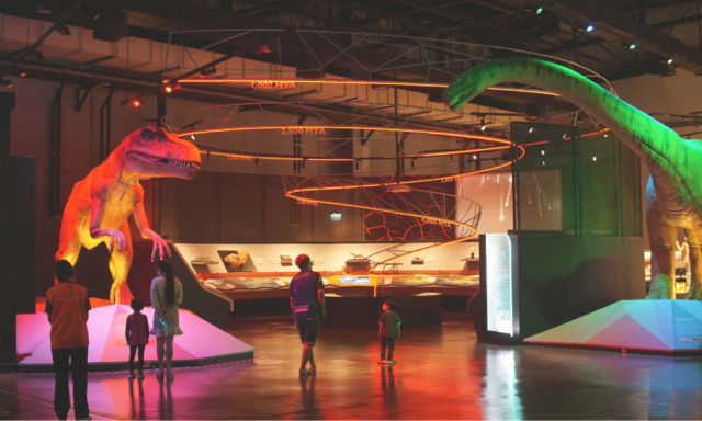 View of a family walking through a dinosaur exhibition at a museum.