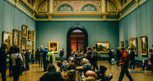Practical Advice for Dealing With Unruly Visitors View of a classic museum gallery filled with paintings and visitors