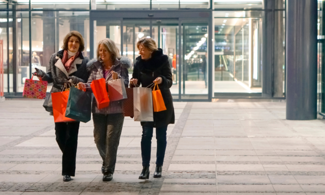 3 women friends walking with multiple shopping bags