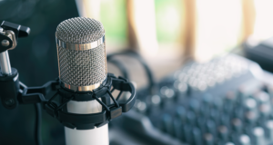 Podcasts for Museum Professionals (And Recommended Episodes) A microphone with podcasting gear in the background.