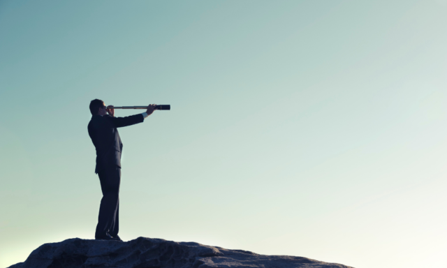 silhouette of a man looking through a telescope on top of mountain