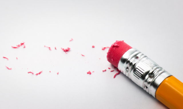 a close up of a pencil with pink eraser shavings on paper