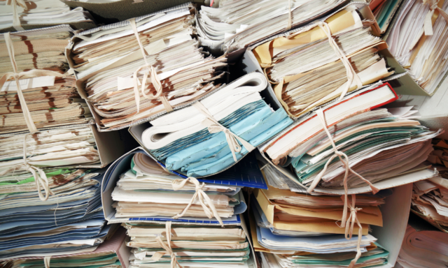 piles and piles of files and paper stacked on top of each other