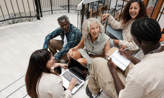 Diverse group of people sitting on stairs having a meeting