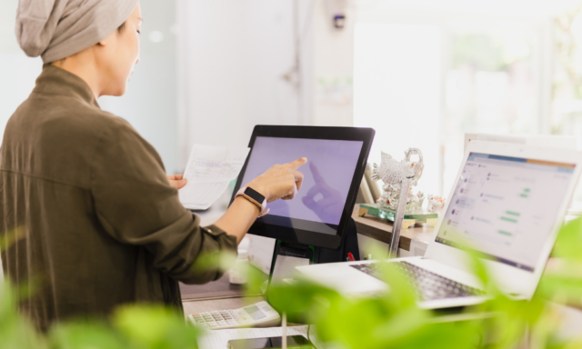 Woman touching screen at a gift shop cash register