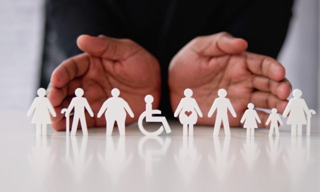 hands cupped around paper cutouts of a diverse group of people