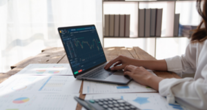 What U.S. Museums Can Learn From the UK’s £8 Billion Cultural Engagement Study Woman working at a table with a laptop, calculator, and printed charts and graphs