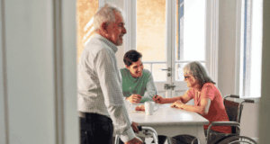 April 28 | Webinar: Conversation on Creative Aging: Making Museums More Accessible to People with Dementia Older adults with walker and wheelchair smiling and interacting with a younger man