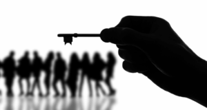 Empowering Museum Boards To Give, Get, and Advocate silhouette of a hand holding a key with a group of people in the background, also in silhouette