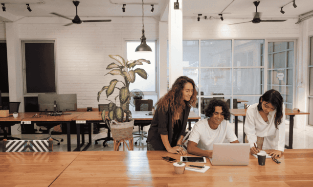 3 coworkers looking at a laptop together