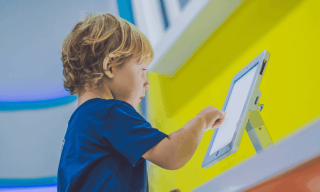 a child playing with a mounted tablet
