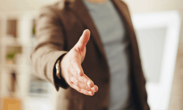 A man's hand reaching out for a handshake