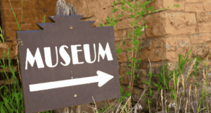 November 12 – 13 | Small Museums, Important Collections Sign stuck in the ground that says "Museum" with an arrow pointing the way