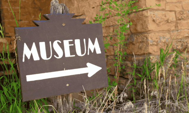 Sign stuck in the ground that says "Museum" with an arrow pointing the way