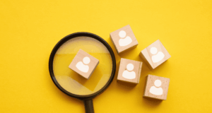 February 26 | Real World HR: Strategies That Strengthen Culture Magnifying glass and small wooden blocks stamped with people icons