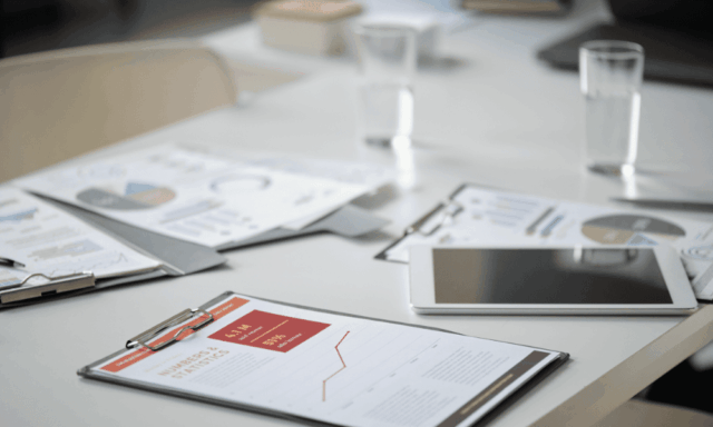 meeting table with papers and a tablet