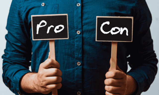 man holding up little pro and con signs.