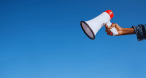 March 12 | Strengthening History Communication: Reframing the Value of History and Your Institution hand holding up a megaphone against a blue sky