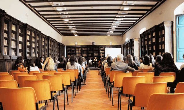 Meeting room with conference attendees in seats